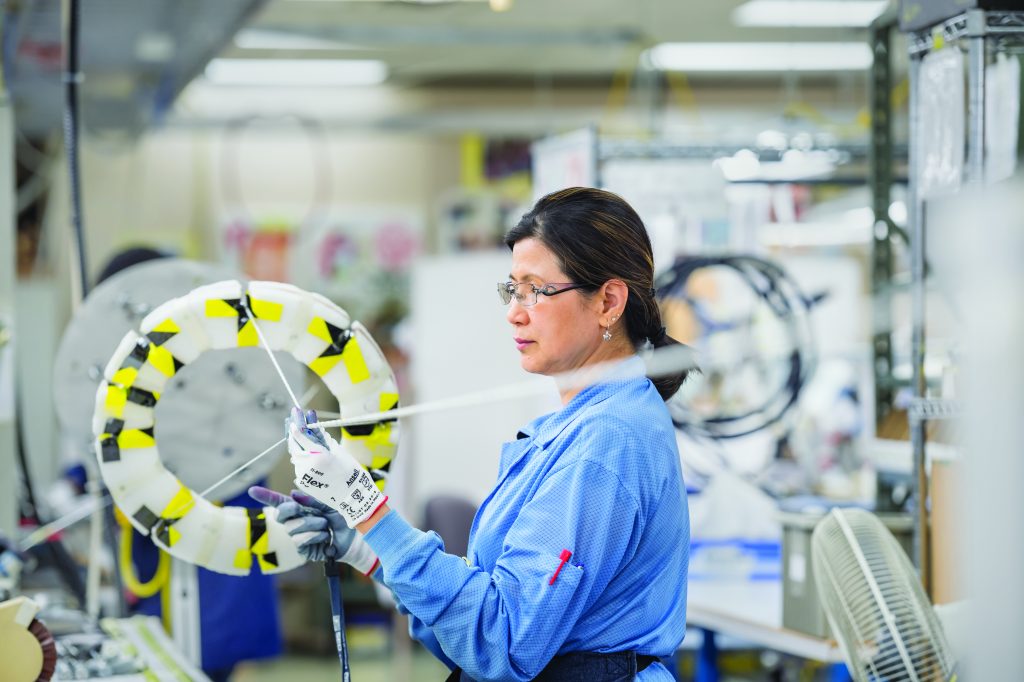 Un scientifique vêtu d'une blouse bleue mène des expériences dans un laboratoire.